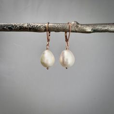 "✦Stunning but simple white natural white teardrop freshwater pearls hang from 14k rose gold filled leverback ear wires. The freshwater pearls have a slight white color and are teardop in shape. The pearls measure approximately 14mm in length and 10mm in diameter.  They dangle about 1-1/4 inches from the top of the ear wire to the bottom of the pearl.  ✦Your jewelry will be packaged in a beautiful and reusable organza bag. All items will be placed in the same organza bag. If you need a separate bag for each item, please leave a comment at check out. ✦Giving your purchase as a gift? If you would prefer that prices not be printed on your invoice, please check \"this item is a gift\".  ✦To receive your item in a gift box with a colorful ribbon, please purchase the gift wrapping option at chec Classic Rose Gold Jewelry With Pearl Drop, Rose Gold Wedding Jewelry With Lever Back Ear Wires, Rose Gold Teardrop Pearl Earrings With Ear Wire, Rose Gold Teardrop Earrings With Pearl Drop, Everyday Rose Gold Pearl Drop Earrings, Delicate Rose Gold Pearl Drop Earrings, Minimalist Rose Gold Teardrop Pearl Earrings, Rose Gold Teardrop Jewelry With Pearl Charm, Delicate Rose Gold Pear-shaped Jewelry