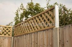 a wooden fence with lattice design on top