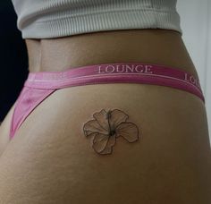 a woman's stomach with a flower tattoo on her lower back and the word lounge written in pink