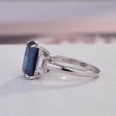 a blue diamond ring sitting on top of a table