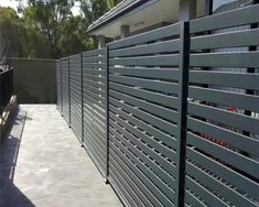 a fence that is next to a building with a grill on the side of it