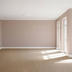 an empty room with pink walls and white trim