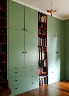 an empty room with many bookshelves and cabinets on the wall, in front of a wooden floor