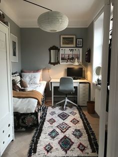 a bedroom with a bed, desk and chair in it next to a doorway that leads to another room