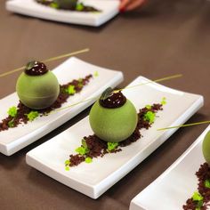 four desserts are arranged on small white plates