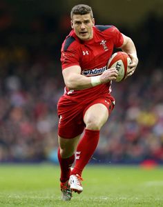 a rugby player running with the ball in his hand