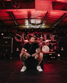 a man sitting on top of a chair in front of a stage