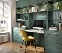 a room with green cabinets and a desk in the corner, along with a rug on the floor