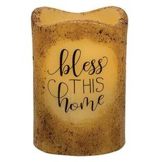 a candle that has the words,'bless this home'in black ink on it