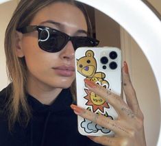 a woman taking a selfie in front of a mirror with her cell phone case