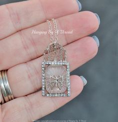 "A stunning vintage necklace made with delicate filigree and camphor glass. It features a single camphor glass piece, surrounded with delicate filigree. Pendant is rectangle shaped, with bezel set center camphor glass. There are clear, paste rhinestones around perimeter of the setting. The pendant features an ornate filigree bail, with filigree butterfly shaped center insert. I've been collecting camphor glass for many years, and have never seen one like this! Pendant is stamped with an unknown Elegant Glass Rectangular Pendant Jewelry, Vintage Intaglio Necklace For Wedding, Art Deco Filigree Necklace For Gift, Art Deco Filigree Necklace As Gift, Art Deco Filigree Necklace Gift, Intaglio Pendant Necklace For Wedding, Vintage Clear Necklace For Wedding, Art Deco Vintage Charm Necklace Gift, Vintage Glass Jewelry For Weddings