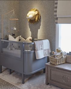 a baby's room with a crib, bed and dresser in grey tones