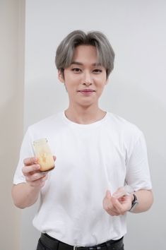 a young man holding a piece of food in one hand and looking at the camera