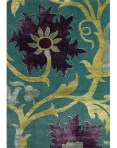 a green rug with purple and yellow flowers on the bottom, in front of a blue background