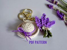 a crocheted keychain with flowers and a hat on it