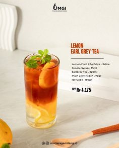 an advertisement for lemon grey tea with orange slices and mint on the table next to it