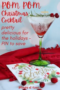 a christmas cocktail in a martini glass on a red table cloth with the words pom - pom christmas cocktail