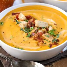 two white bowls filled with soup and garnished with croutons on top