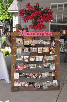 a sign that has pictures on it in front of a house with red flowers hanging from it