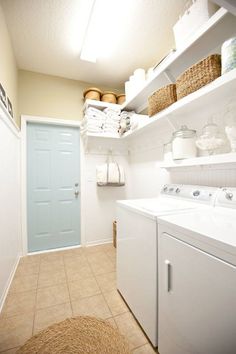 a washer and dryer sitting in a room next to a door with baskets on it