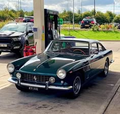 an old car is parked at a gas station