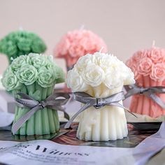 three small vases filled with flowers on top of a table next to each other