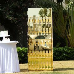 a cake sitting on top of a table next to a tall glass case filled with champagne bottles