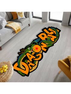 an area rug with the word dragon on it in orange and black, sitting next to a couch