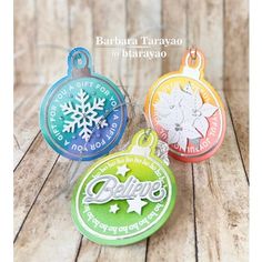 three different colored tags with snowflakes on them