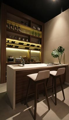 two bar stools sit in front of a counter with wine bottles on the shelves