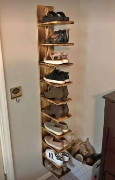 a wooden shoe rack filled with lots of shoes in a room next to a door