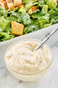 a salad with dressing in a glass bowl