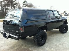 a large black truck parked in a parking lot