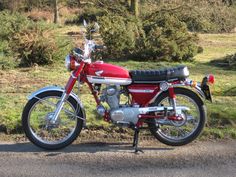 a red motorcycle is parked on the side of the road