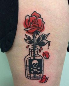 a skull and rose tattoo on the back of a woman's thigh, with an image of a skeleton in a jar