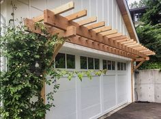 a white garage with a wooden pergolated roof and attached to the side of it