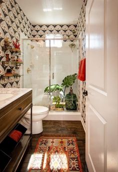 a bathroom with a toilet, shower and rug on the floor in front of it