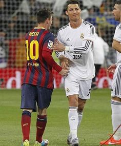 two soccer players talking to each other on the field