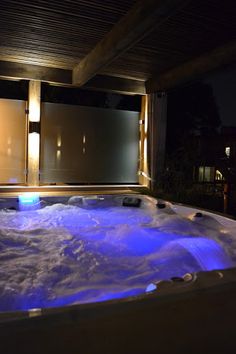 an indoor hot tub with blue lights in it