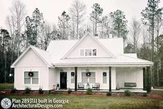 a white house sitting in the middle of a forest