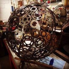 a large metal ball sitting on top of a table next to a pile of junk