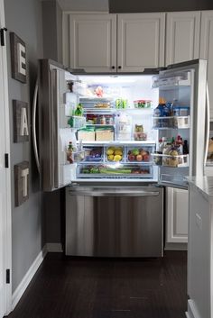 an open refrigerator with its door wide open and full of food in the fridge is shown