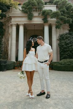 a man and woman standing in front of a building