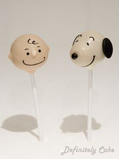 two lollipops with faces drawn on them sitting side by side in front of each other