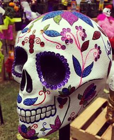 a colorfully painted skull sitting on top of a wooden table