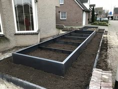 an empty garden bed in front of a house