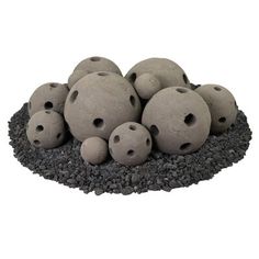 a pile of rocks sitting on top of a black rock covered in small holes and gravel