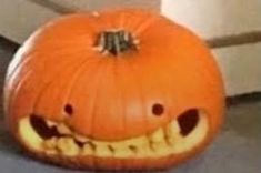 an orange pumpkin with teeth carved into it