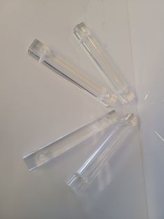 four clear plastic tubes sitting on top of a white table