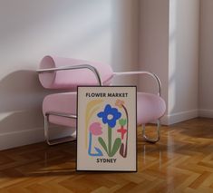 a pink chair sitting next to a flower market sign on top of a hard wood floor